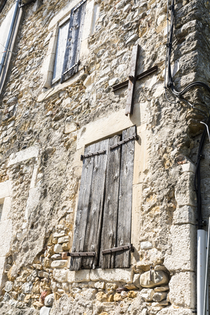 Stone wall in France with old shop and crossの写真素材