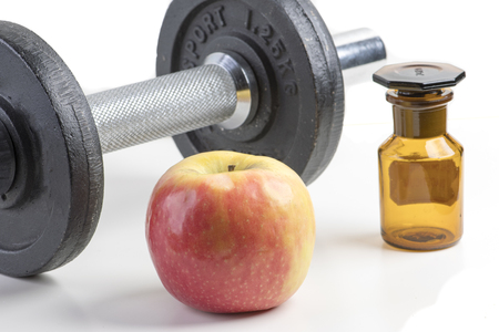 Sport dumbbell with apple and medicine bottleの写真素材