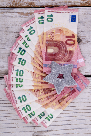 ten euro banknotes on white wood with silver starの写真素材
