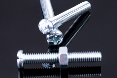 Screw with one nut and two screws in the backgroundの写真素材