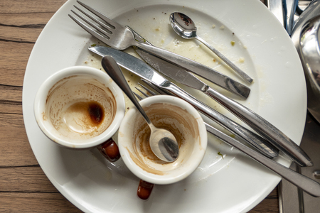 dirty dishes with espresso cups, knife and spoonの写真素材