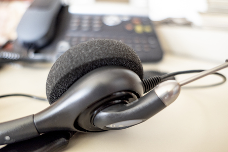 Headset with telephone in the background in the office on the deskの写真素材