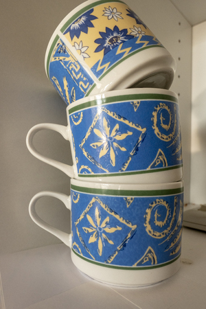 three blue cups stacked on top of each other in a cupboardの写真素材