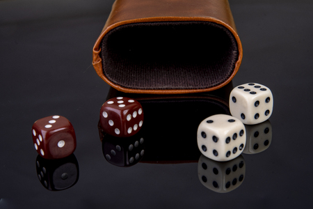 Dice with dice cup on black backgroundの写真素材