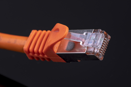 orange data cable for fast internet on black background for a modern home installationの写真素材