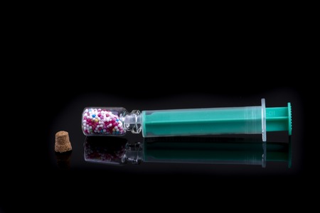 medical syringe with sugar pearls - diabetes on black backgroundの写真素材