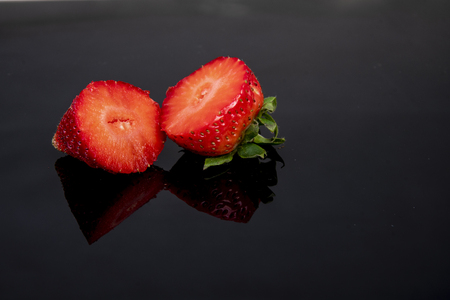 fresh strawberry rich in vitamins cut open on a dark backgroundの写真素材