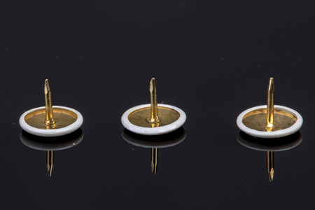 three white pins on a black background with the tip up sharp and pointedの写真素材