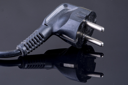 Power plug on reflective black surfaceの写真素材