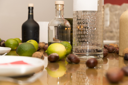 Table covered with limes and alcoholic bottles of schnapps and gin before a partyの写真素材
