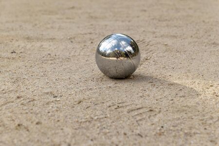 silver shiny boules ball in the sandの写真素材