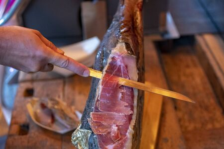 large ham is cut directly from the legの写真素材