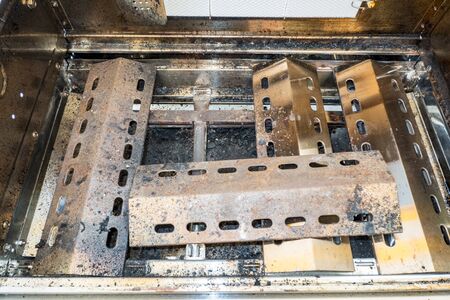 Fuel elements of a gas barbecue rusted and contaminatedの写真素材