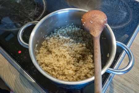 Pot with cooking spoon and boiling bulgurの写真素材