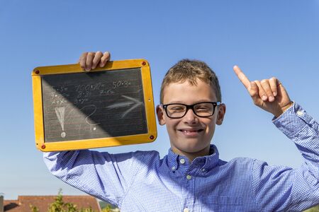 Boy with glasses and blackboard has a brilliant idea