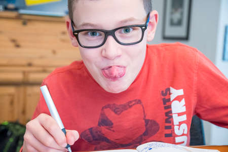 Caucasian with glasses close-up while writing in booklet