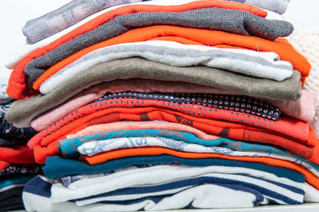 Clothes stacked in different colors in the wardrobe