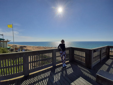 Woman sunbathing on a wooden jetty by the Atlantic Ocean