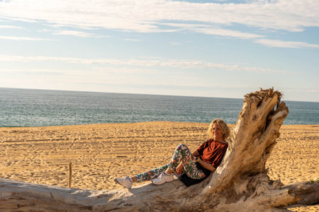 Boy looking into the distance with cap on the beach at the Atlantic Oceanの写真素材
