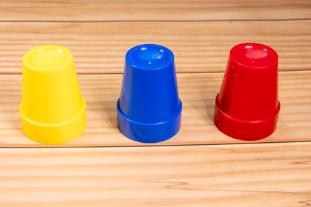 Colorful plastic cups on a wooden background. Selective focus.の写真素材