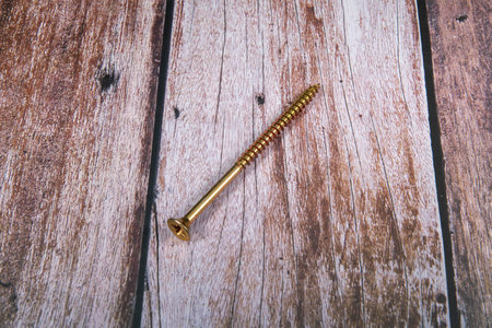Golden screw on wooden background. top view Copy space for text.の写真素材