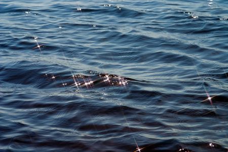 blue water textured surface with X-shaped glaresの写真素材