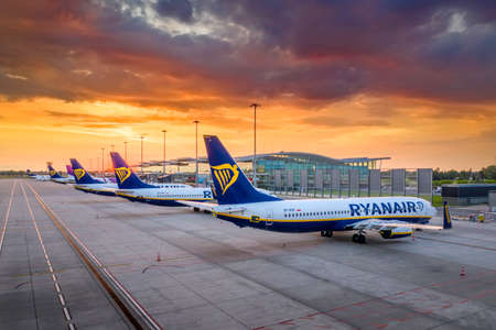 Wroclaw, Poland - June 17, 2020: Beautifull sunset and low cost airline Ryanair airplane tails in front of Wroclaw Airport terminal. Comercial aircraft seen from the side in the airport apronのeditorial素材