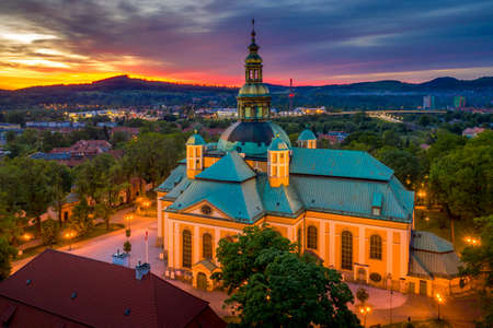 Church of the Exaltation of the Holy Cross in Jelenia Gora in Poland and the surrounding mountains at beautiful sunset. View of the city skyline from the droneの写真素材