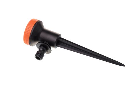 Side view of a black plastic garden sprinkler for irrigation with orange head and multiple water modes, isolated on white backgroundの写真素材