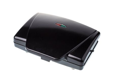 Closed black waffle maker machine, isolated on white backgroundの写真素材
