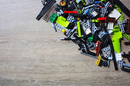Close-up on the multi-colored details of childrens plastic toy bricks lying on the table. Top view....