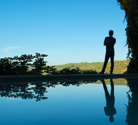 Silhouette of the men staying beside of the pool.の写真素材