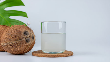 Whole coconut and glass of coconut water with green leaf on white background Clear details and vi...の素材