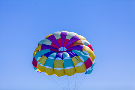 Multi coloured parachute over the blue sky