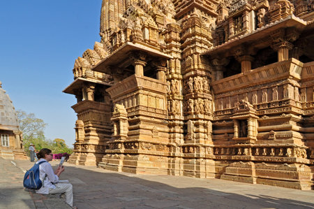 Khajuraho, Madhya Pradesh , India - March 2011    Foreign visitor studying at Lakshmana Temple, dedicated to Lord Vishnu, Western Temples of Khajuraho on 21st March, 2011  Khajuraho is an UNESCO world heritage site, a popular tourist destination from all のeditorial素材