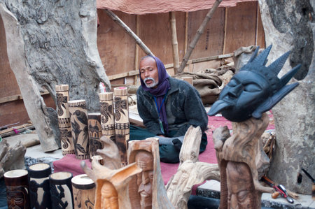 KOLKATA, WEST BENGAL , INDIA - DECEMBER 14TH 2013   Unidentified man making wooden Artworks of handicraft, at Handicraft Fair in Kolkata - the biggest handicrafts fair in Asia のeditorial素材