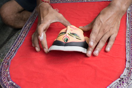 KOLKATA, WEST BENGAL, INDIA - 13 SEPTEMBER 2015: An unidentified artist preparing clay idol of...