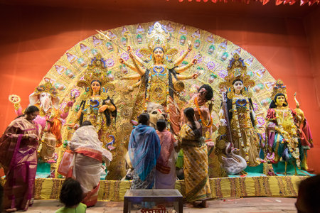 KOLKATA , INDIA - OCTOBER 18, 2015 : Married Bengali women worshipping Durga idol at Puja pandal,...