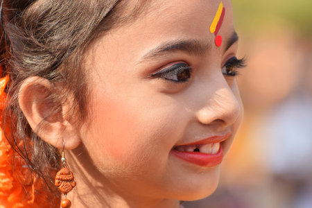 KOLKATA , INDIA - MARCH 12, 2017: Young girl with spring festive make up with flowers , joyful expression at Holi/Spring festival,known as Dol (in Bengali) or Holi (in Hindi) celebrating arrival of Spring in India.のeditorial素材