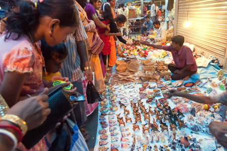 KOLKATA, WEST BENGAL , INDIA - 12TH AUGUST 2012 : Indian woman choosing ornaments from out door local market place. India is boomimg with middle class consumers in society.のeditorial素材