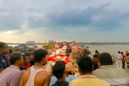 KOLKATA, WEST BENGAL, INDIA - 30 SEPTEMBER 2017: Idol of Goddess Durga is being immersed in Holy river Ganges. Celebrated by Hindus asのeditorial素材