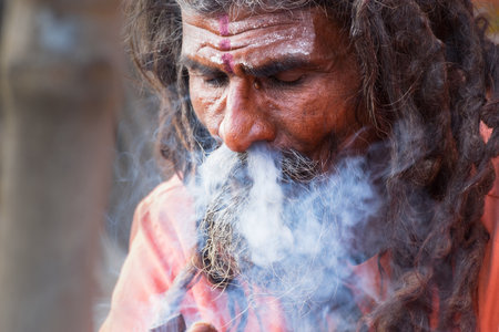 BABUGHAT, KOLKATA, WEST BENGAL / INDIA - 10TH JANUARY 2015 : Hindu Sadhu smoking marijuana, locally called Ganja, a form of canabis sativa .のeditorial素材