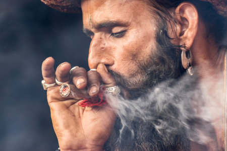 BABUGHAT, KOLKATA, WEST BENGAL / INDIA - 10TH JANUARY 2015 : Hindu Sadhu smoking marijuana, locally called Ganja, a form of canabis sativa .のeditorial素材