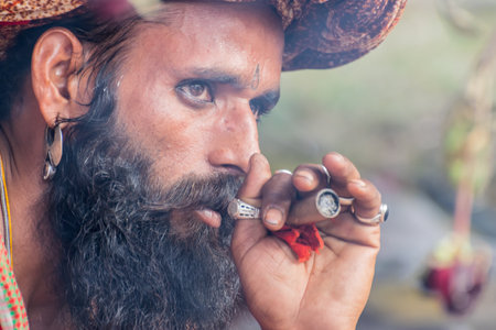 BABUGHAT, KOLKATA, WEST BENGAL / INDIA - 10TH JANUARY 2015 : Hindu Sadhu smoking marijuana, locally called Ganja, a form of canabis sativa .のeditorial素材