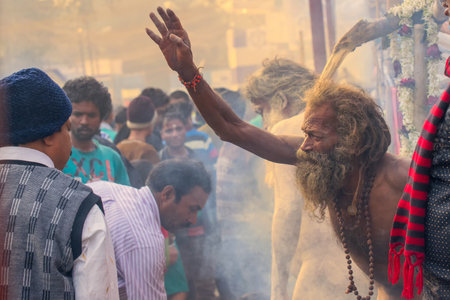 BABUGHAT, KOLKATA, WEST BENGAL / INDIA - 11TH JANUARY 2015 : Hindu Sadhu with white ash applied on body and face, blessing Indian devotee men.のeditorial素材