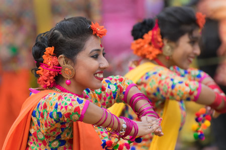 KOLKATA , INDIA - MARCH 12, 2017: Girl dancers, dressed in sari (traditional Indian dress) and Palash flowers (Butea monosperma) make up, dancing at Dol (in Bengali) or Holi (in Hindi) festival.のeditorial素材