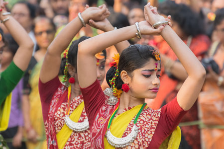 KOLKATA , INDIA - MARCH 12, 2017: Dancing poses of girl dancers , dressed in yellow and red coloured sari (traditional Indian dress) dancing at Spring festival, ie, Dol / Holi.のeditorial素材