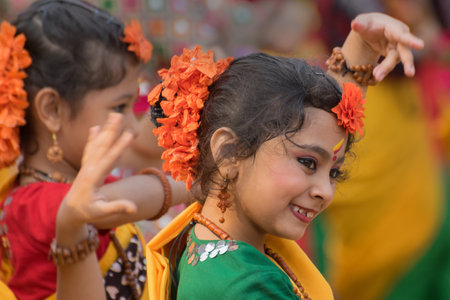 KOLKATA , INDIA - MARCH 12, 2017: Girl dancers, dressed in sari (traditional Indian dress) and Palash flowers (Butea monosperma) make up, dancing at Dol (in Bengali) or Holi (in Hindi) festival.のeditorial素材