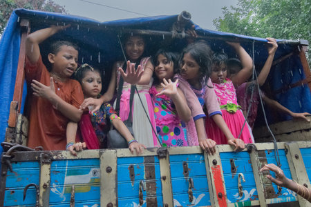 KOLKATA, WEST BENGAL , INDIA - JUNE 25TH 2017 : Rain soacked child devotees around Rath (chariot) of...