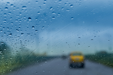 An abstract blurred image of raindrops falling on glass in monsoon seasonの写真素材